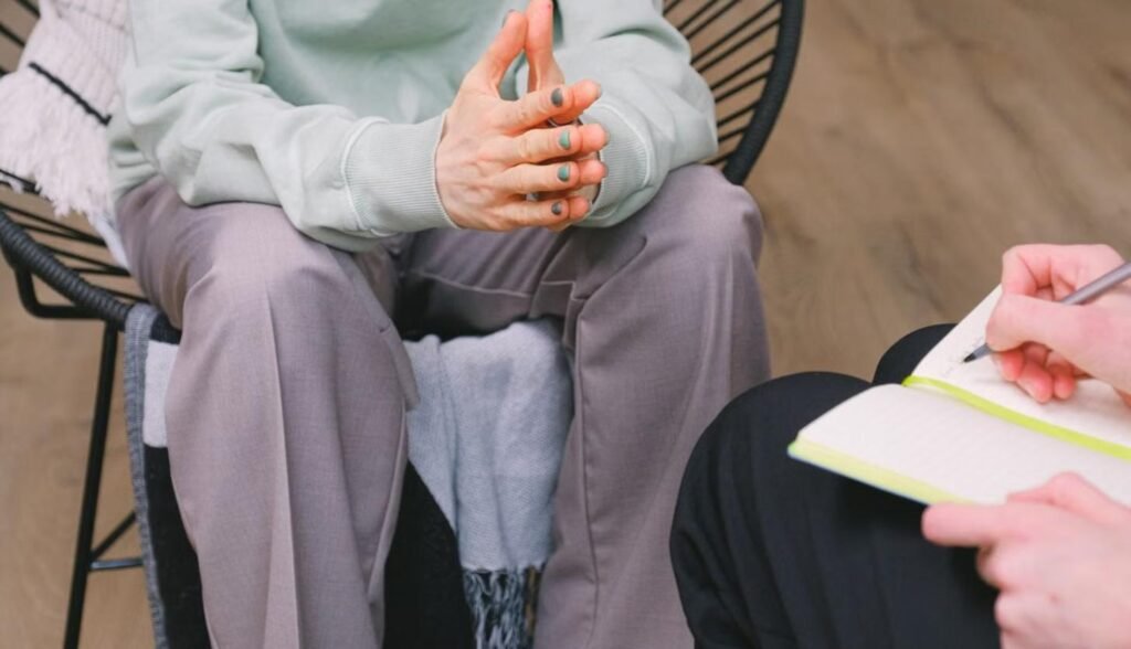 Sesión de acompañamiento psicológico, terapeuta tomando notas mientras escucha a la paciente
